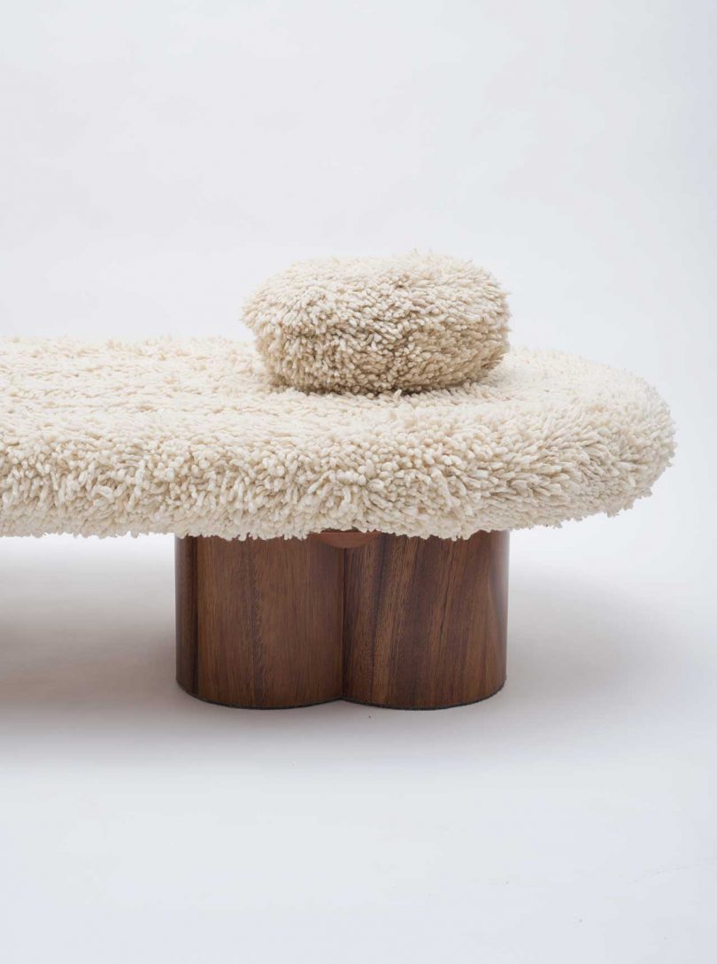 boucle daybed with two pillows and wooden legs