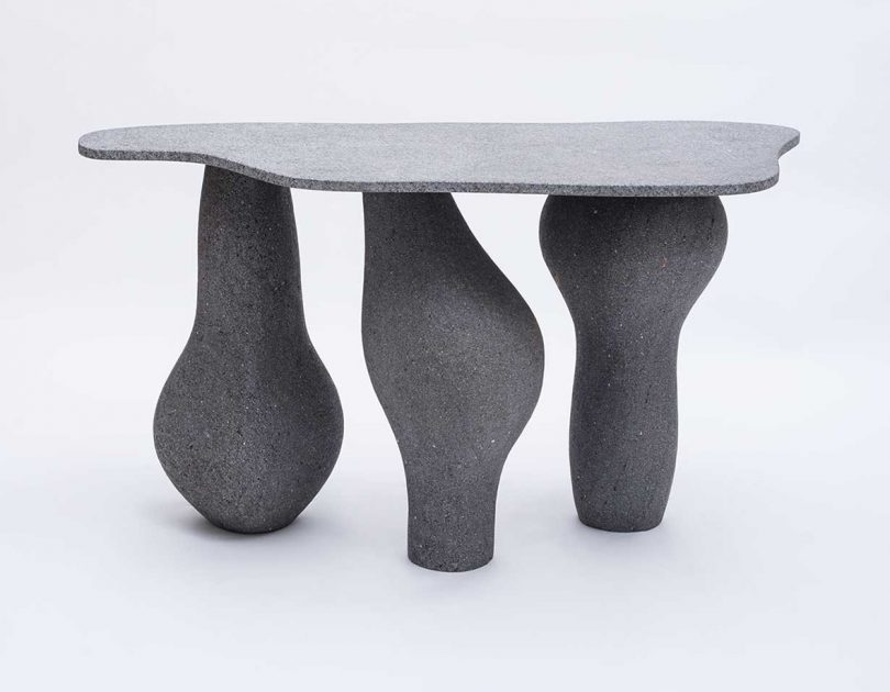 charcoal grey table with three abstractly shaped legs