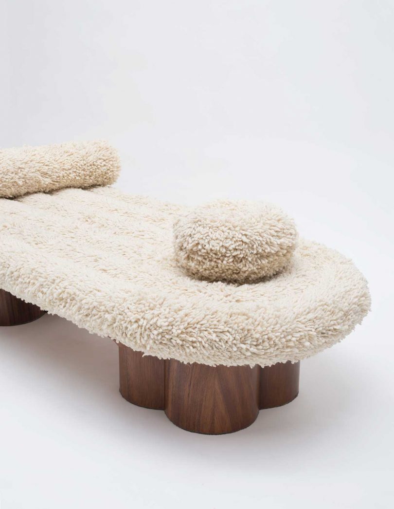 boucle daybed with two pillows and wooden legs