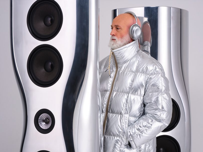 futuristic silver and black space with light-skinned man wearing a silver puffer jacket and silver headphones