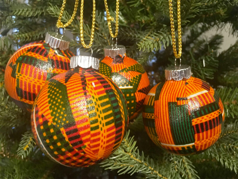 four African Kente patterned ornaments hanging on tree
