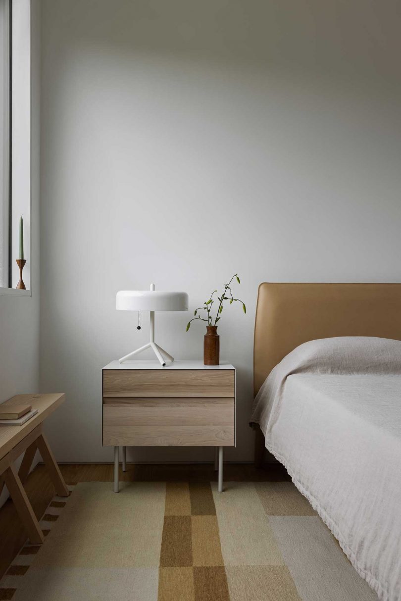 view of modern bedroom with half shot of bed and side table