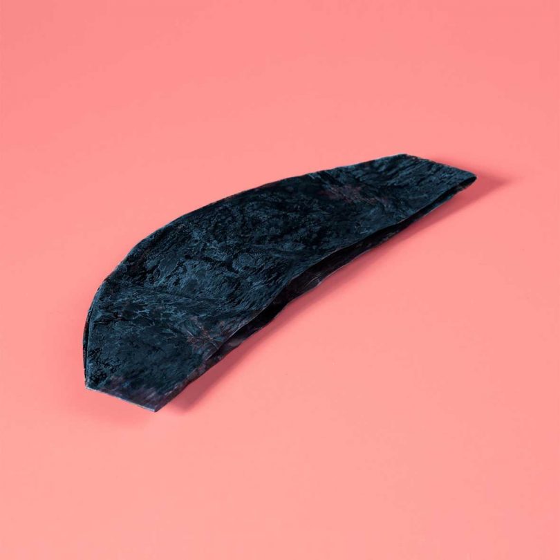 flat blue tinted material laying on pink backdrop