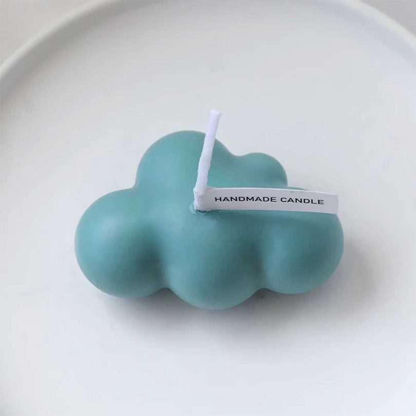 small blue cloud-shaped candle on white plate 