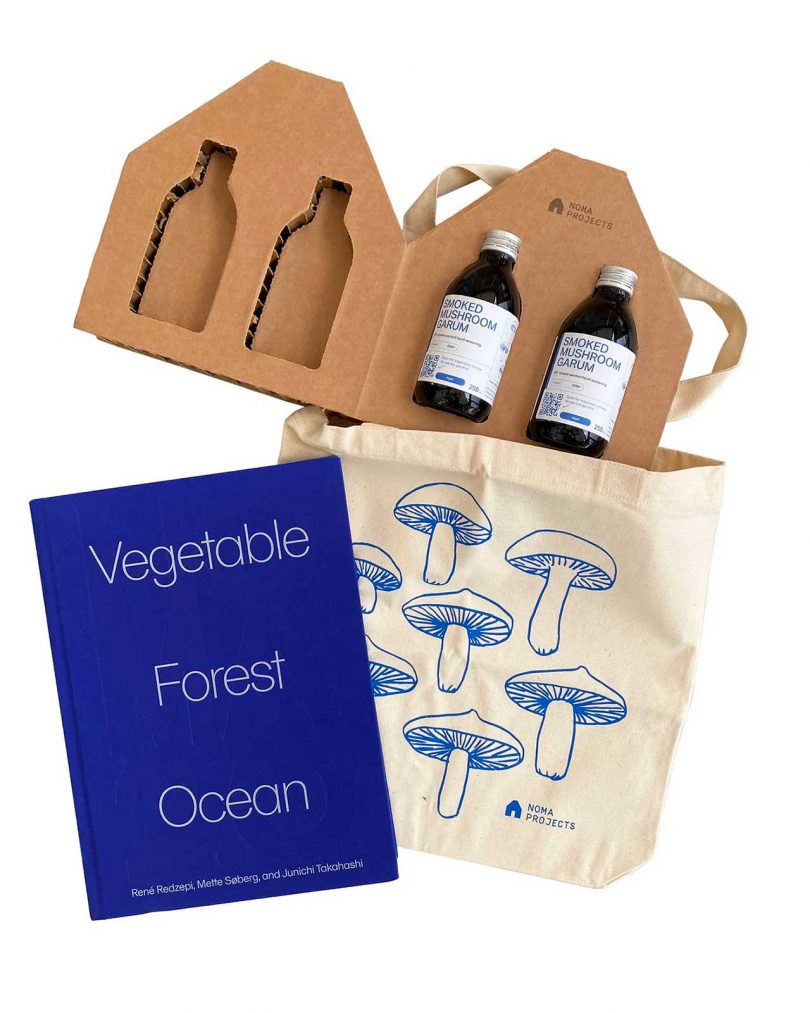 gift set of two bottles packaged in cardboard, a mushroom tote, and book