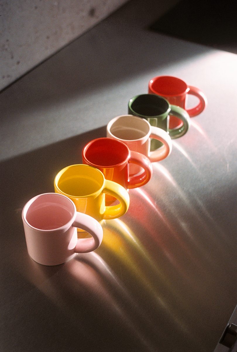 stack of multicolor mugs on a stainless steel kitchen counter