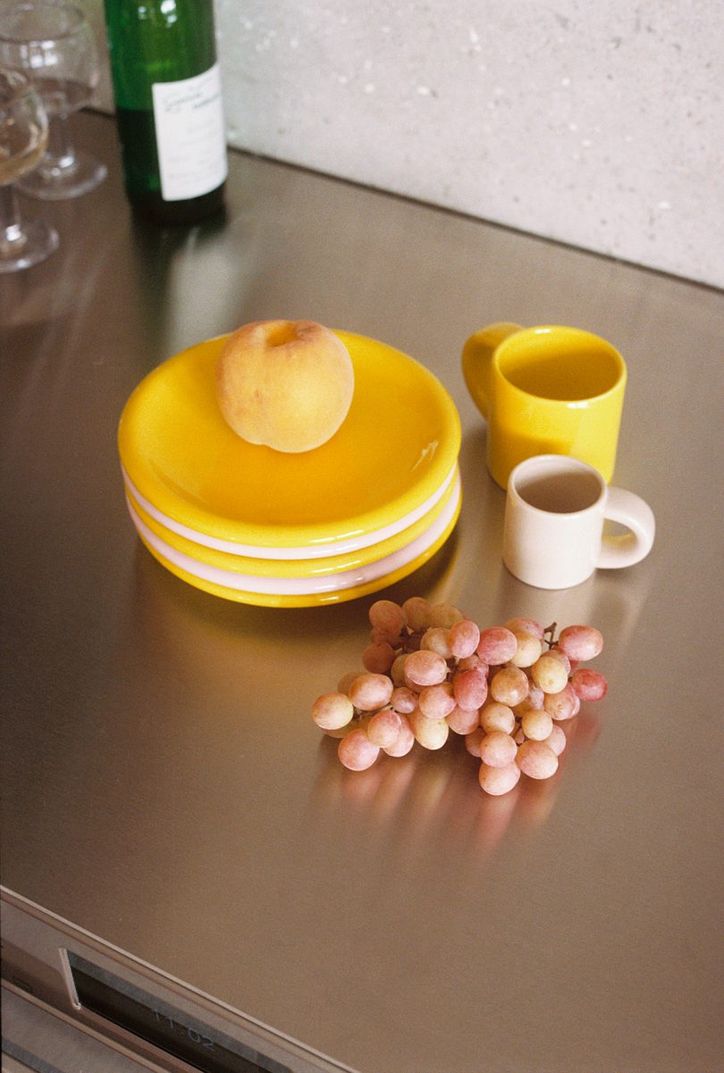 set of yellow and cream tableware with grapes on a kitchen counter