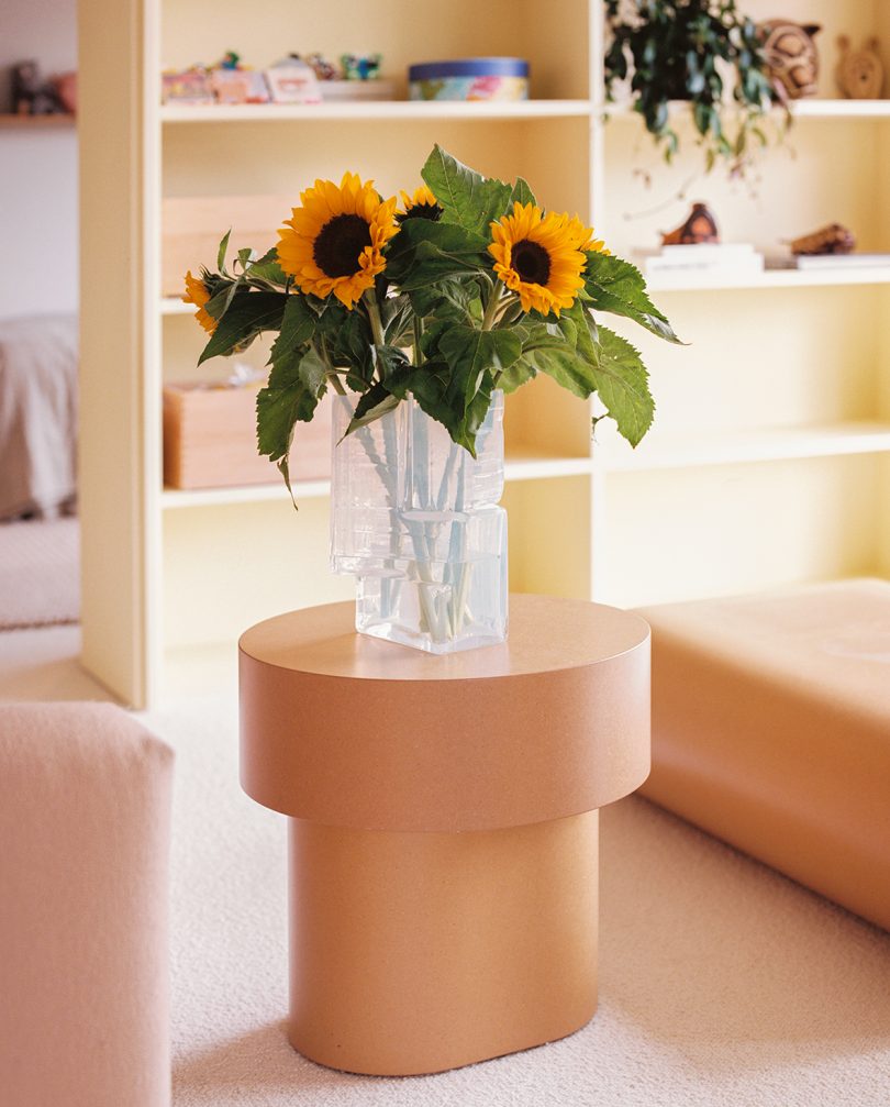 white glass vase with sunflowers flowers on a side table