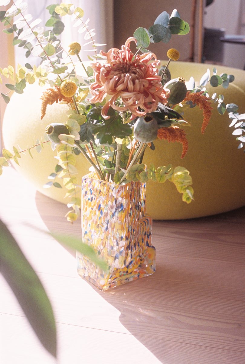 white glass vase with sunflowers flowers on a side table