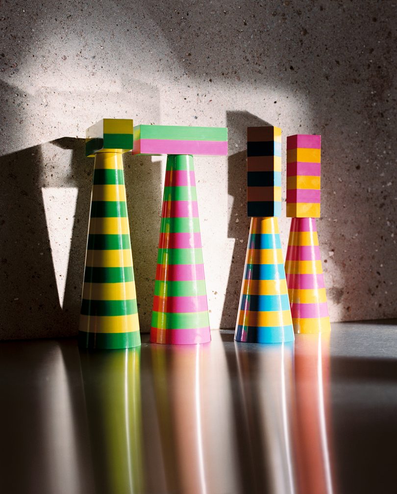 four colorful striped salt and pepper grinders on a kitchen counter