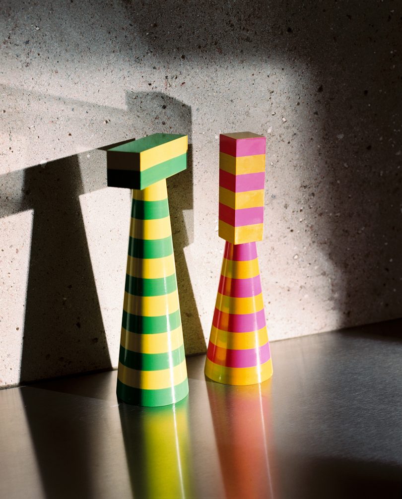 two colorful striped salt and pepper grinders on a kitchen counter