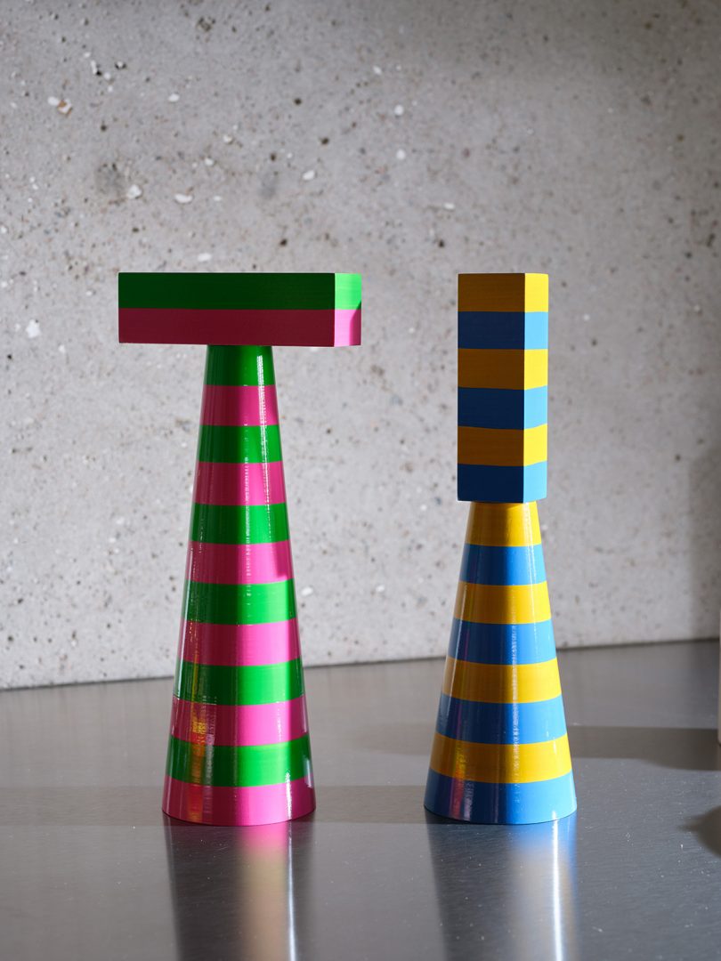 two colorful striped salt and pepper grinders on a kitchen counter