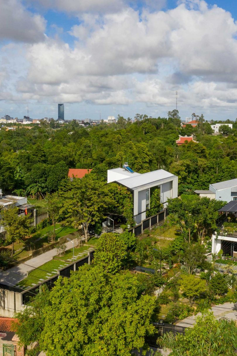 aerial view of modern white house surrounded by greenery
