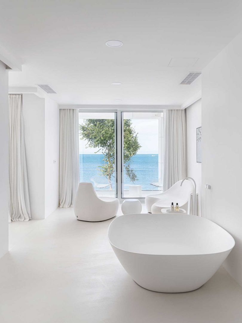 large white bathroom of minimalist all-white modern house with views of the sea
