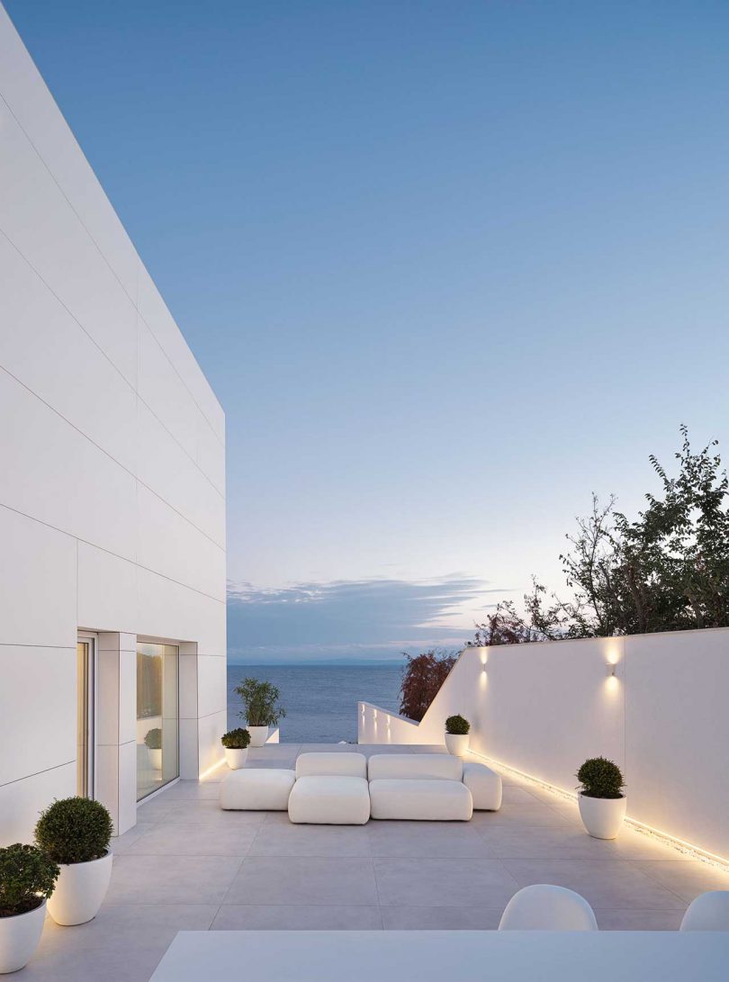 نمای بیرونی مینیمالیستی خانه سفید مدرن با چشم‌اندازی از اقیانوس