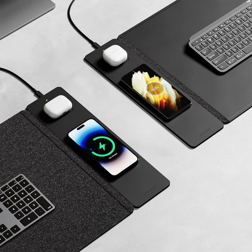 Side by side black ALTI wireless desk mats, both charging iPhones and AirPods. 