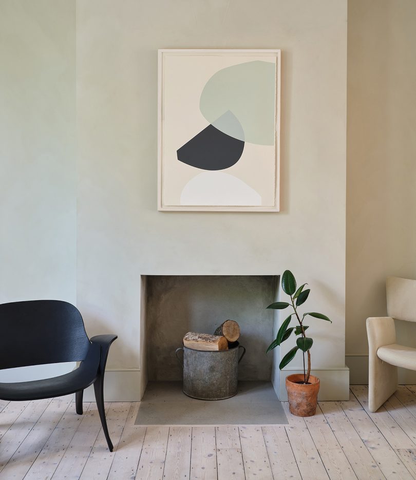 styled living space with chairs, a modern fireplace, and a piece of abstract framed art