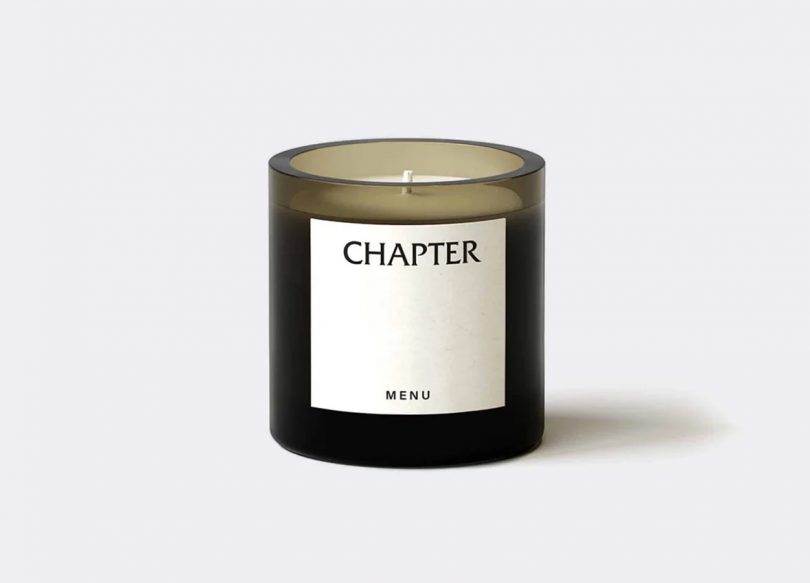 dark grey glass jar candle with a white label that reads CHAPTER MENU