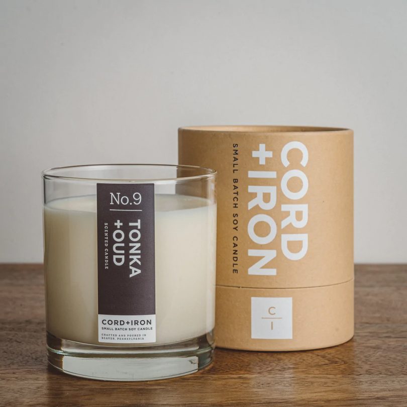 glass jar candle with accompanying round brown box that reads CORD+IRON