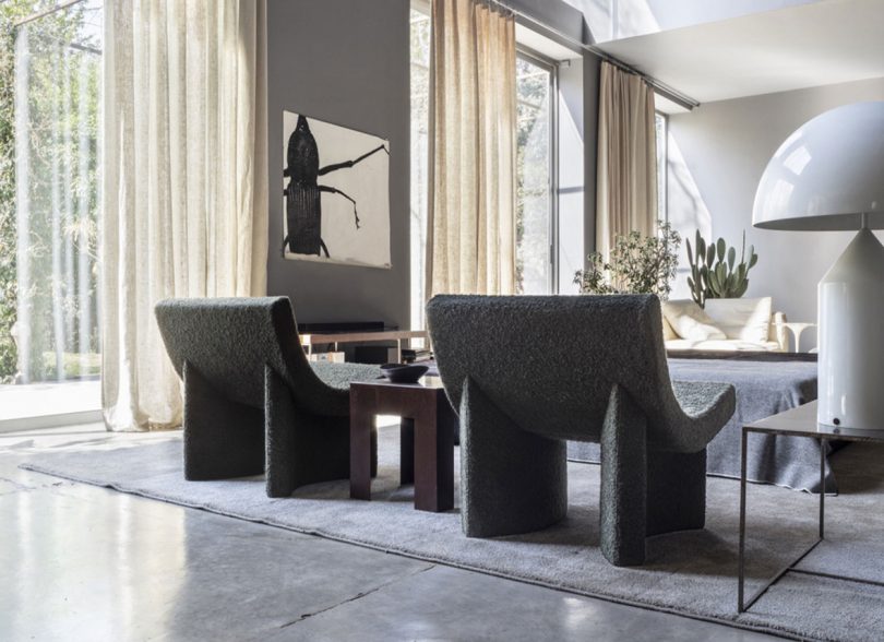 two curved dark grey lounge chairs in styled living space