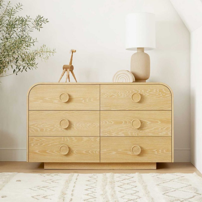 modern light wood dresser with rounded curved top and large circular handles