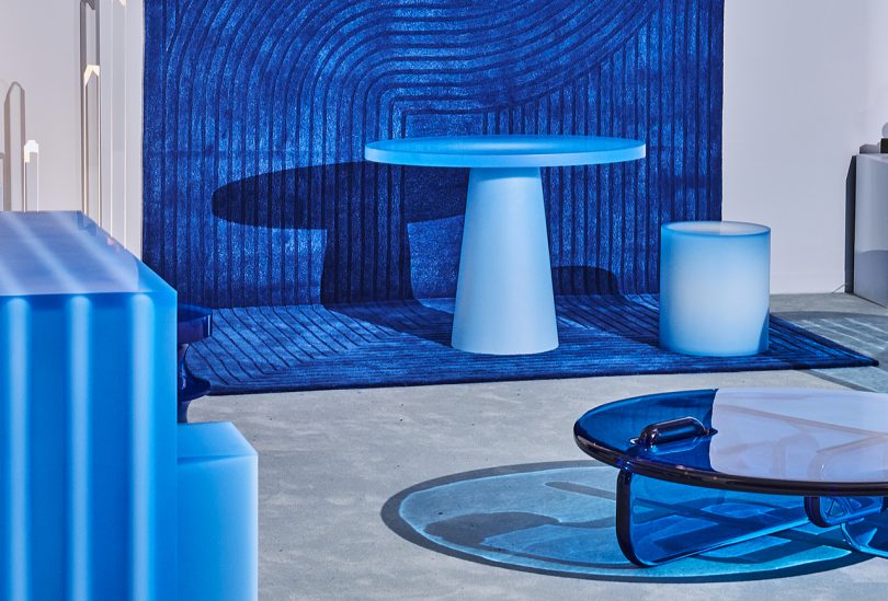 blue dining table, stool coffee table, and wall at a blue-themed exhibition