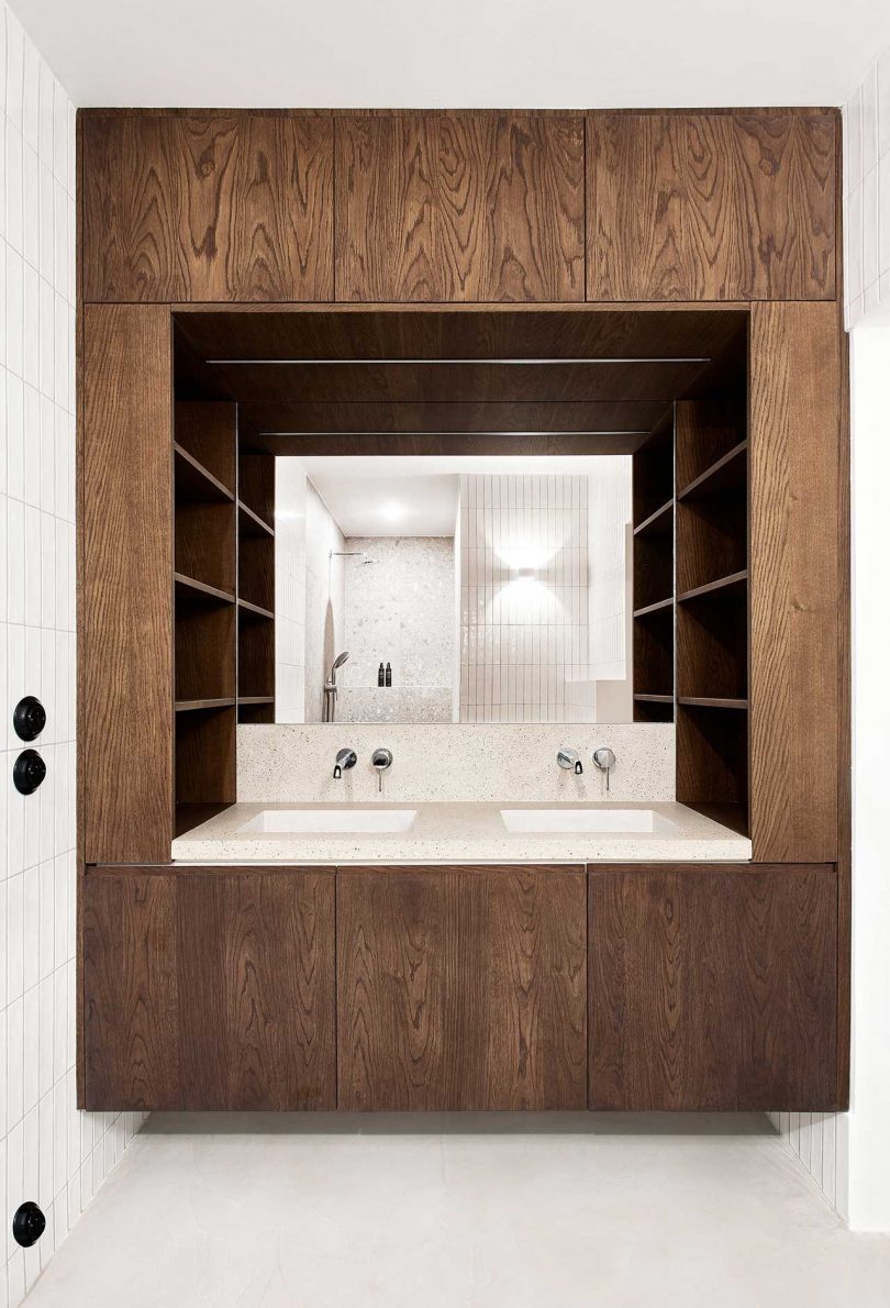 modern bathroom with double sinks built within dark wood shelving