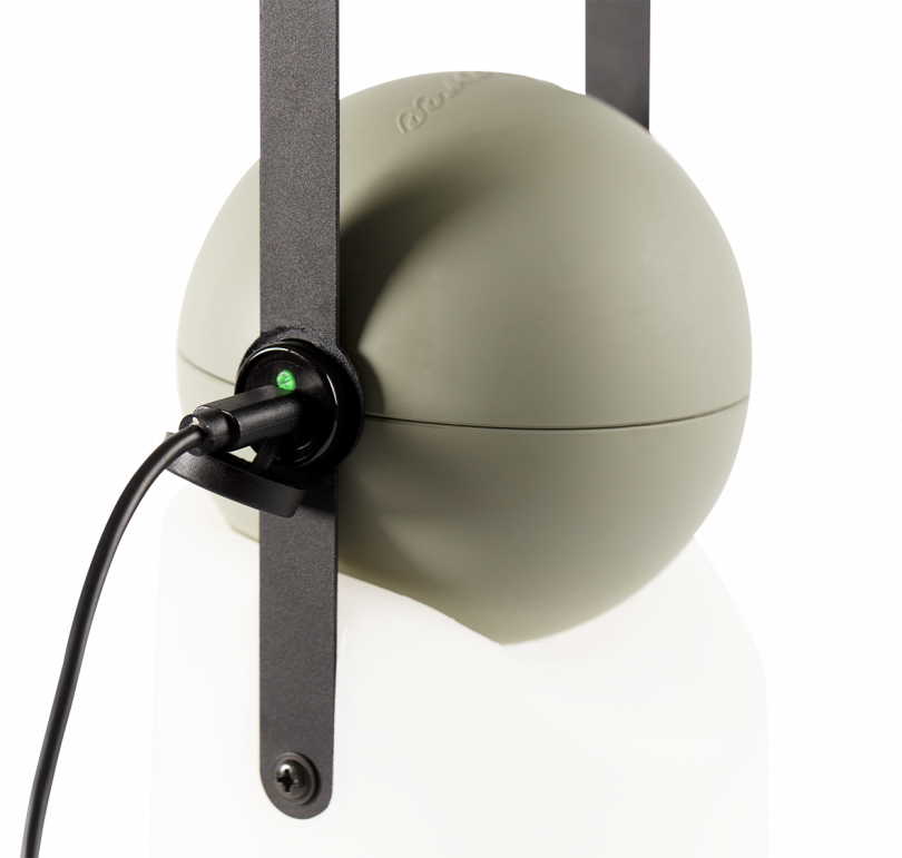 portable lamp with a white base, grey top, and black strap handle being charged on a white background