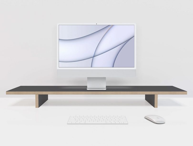 Compustands Simple Monitor Stand in black with iMac on top with Apple keyboard and mouse.