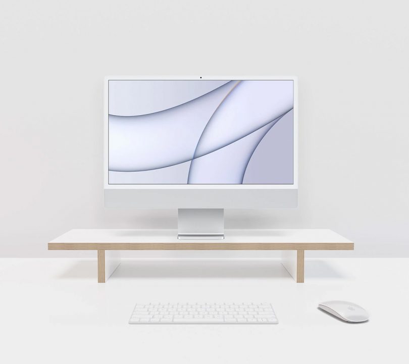 Compustands Simple Monitor Stand in white with iMac on top with Apple keyboard and mouse.