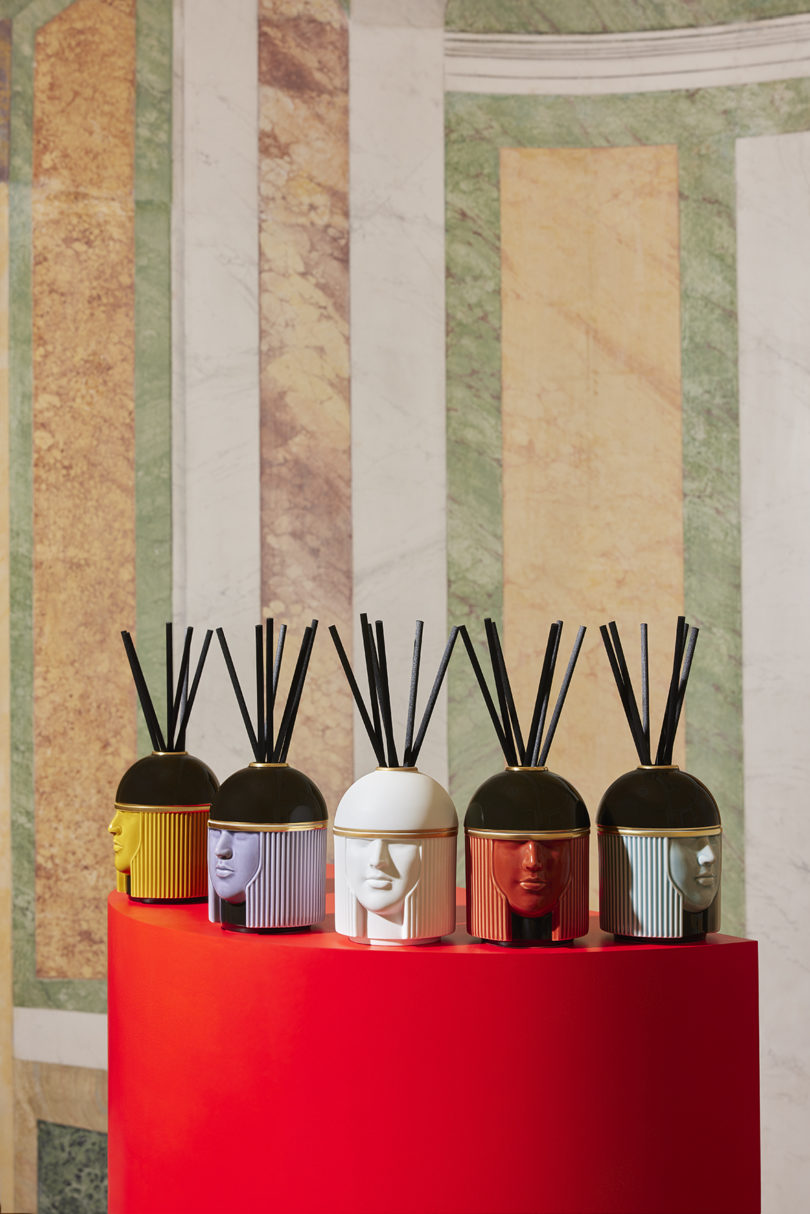 five reed diffusers shaped like heads in different colors