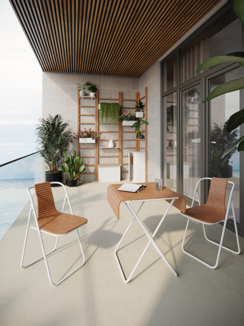 balcony with folding table and two folding chairs and a wall system of plant organization