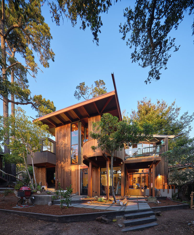 exterior of wood living structure surrounded by green trees