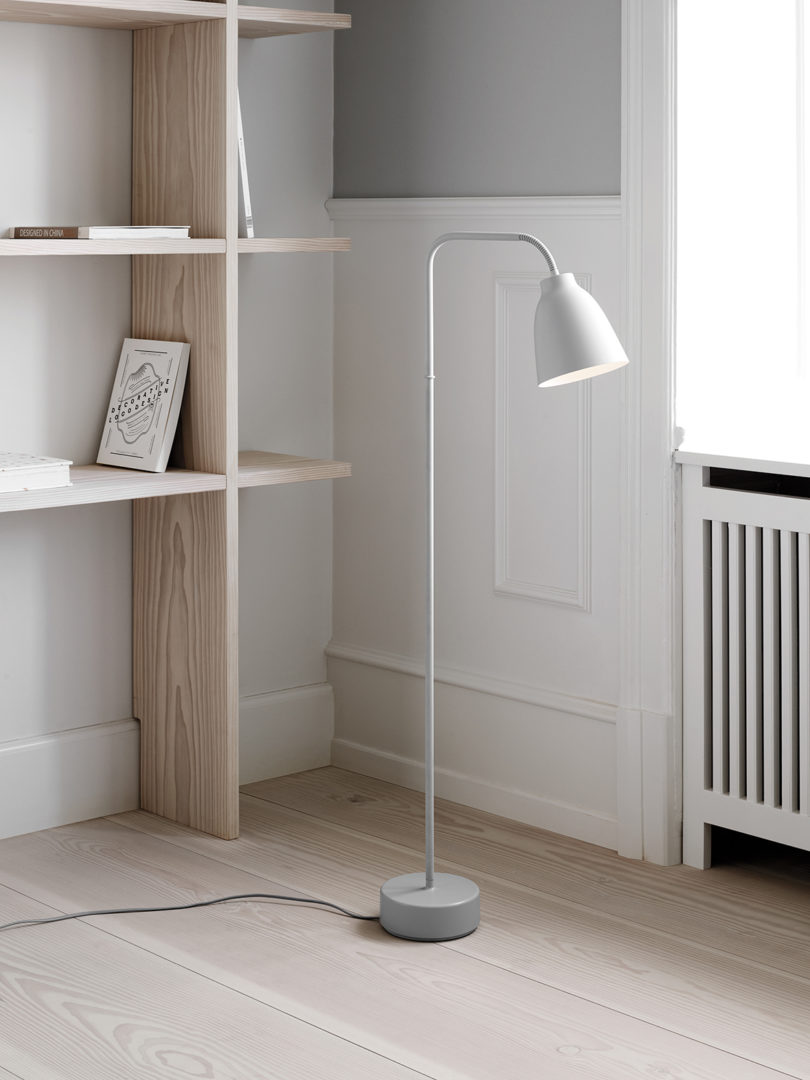 modern white floor lamp in styled space with bookcase