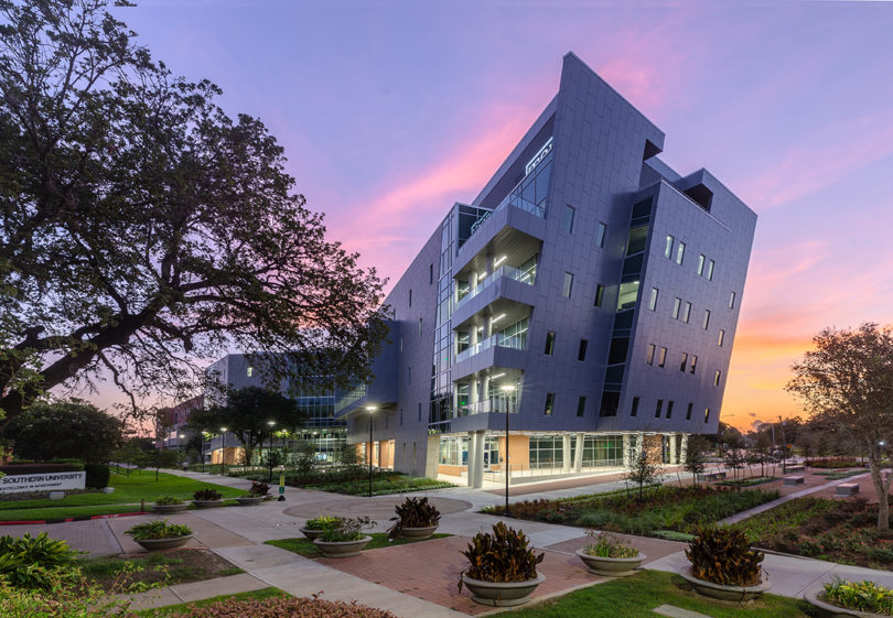 modern university building in front of a sunset