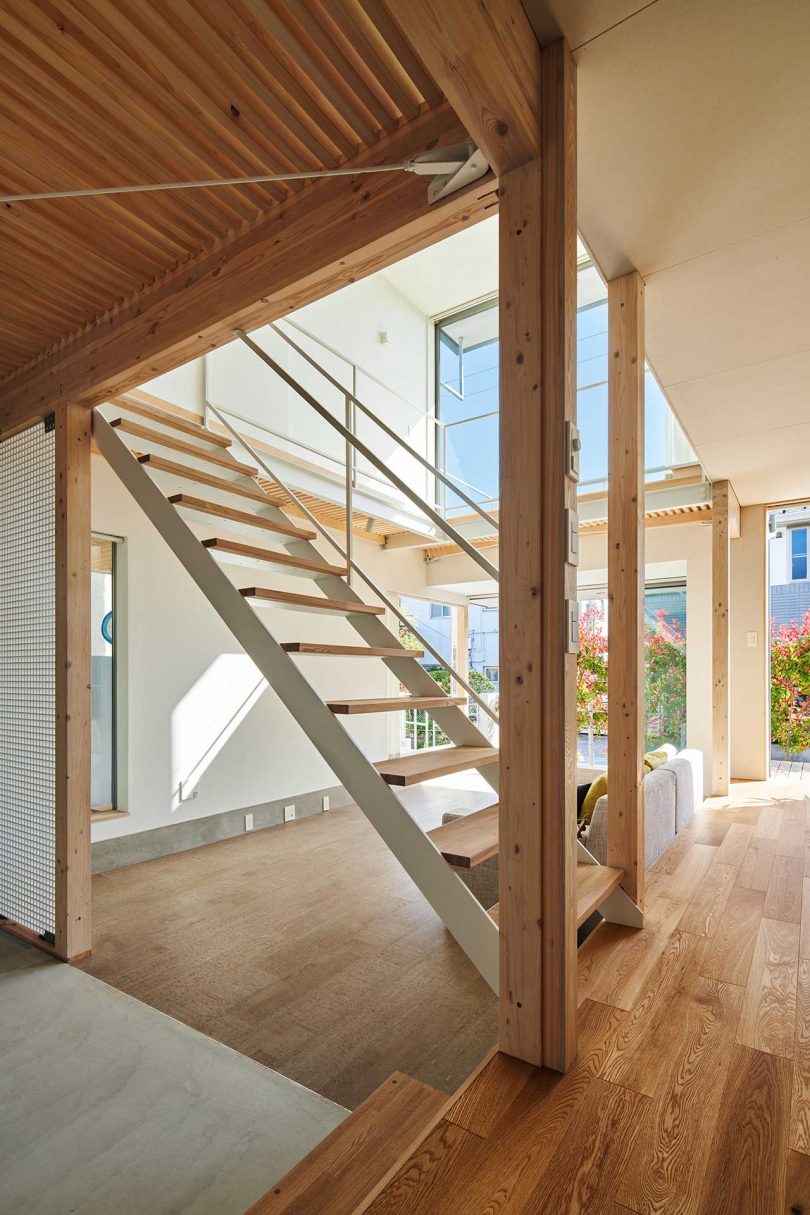 interior of modern Japanese house with double height living room and white open stairs