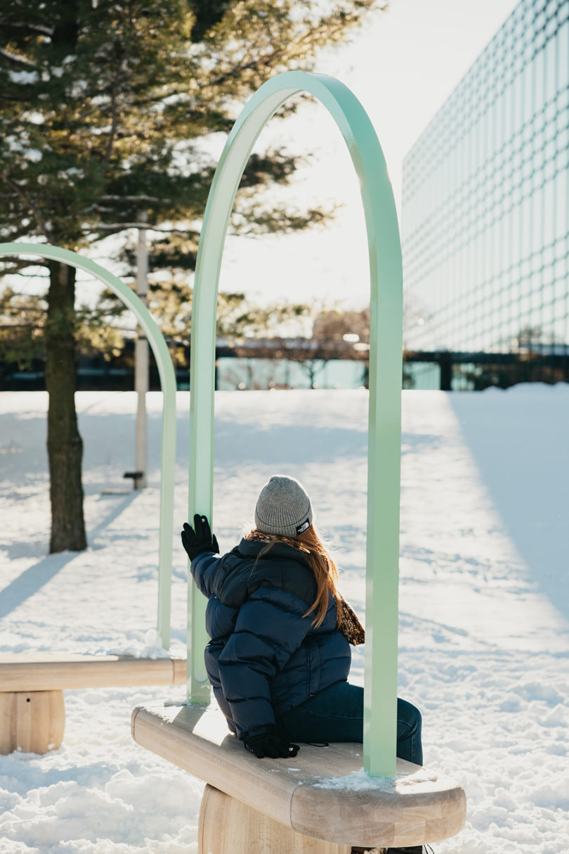 benches outdoors in the snow with a person sitting on one