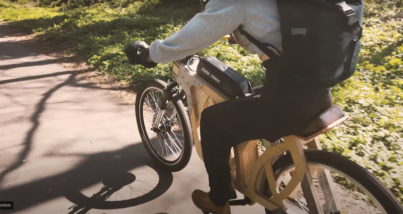 person riding an electric bike with plywood frame