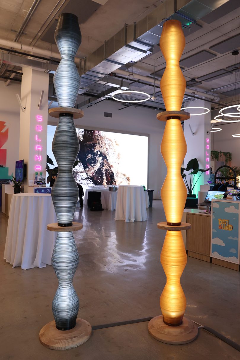 two columns of illuminated silver and gold at an art exhibition
