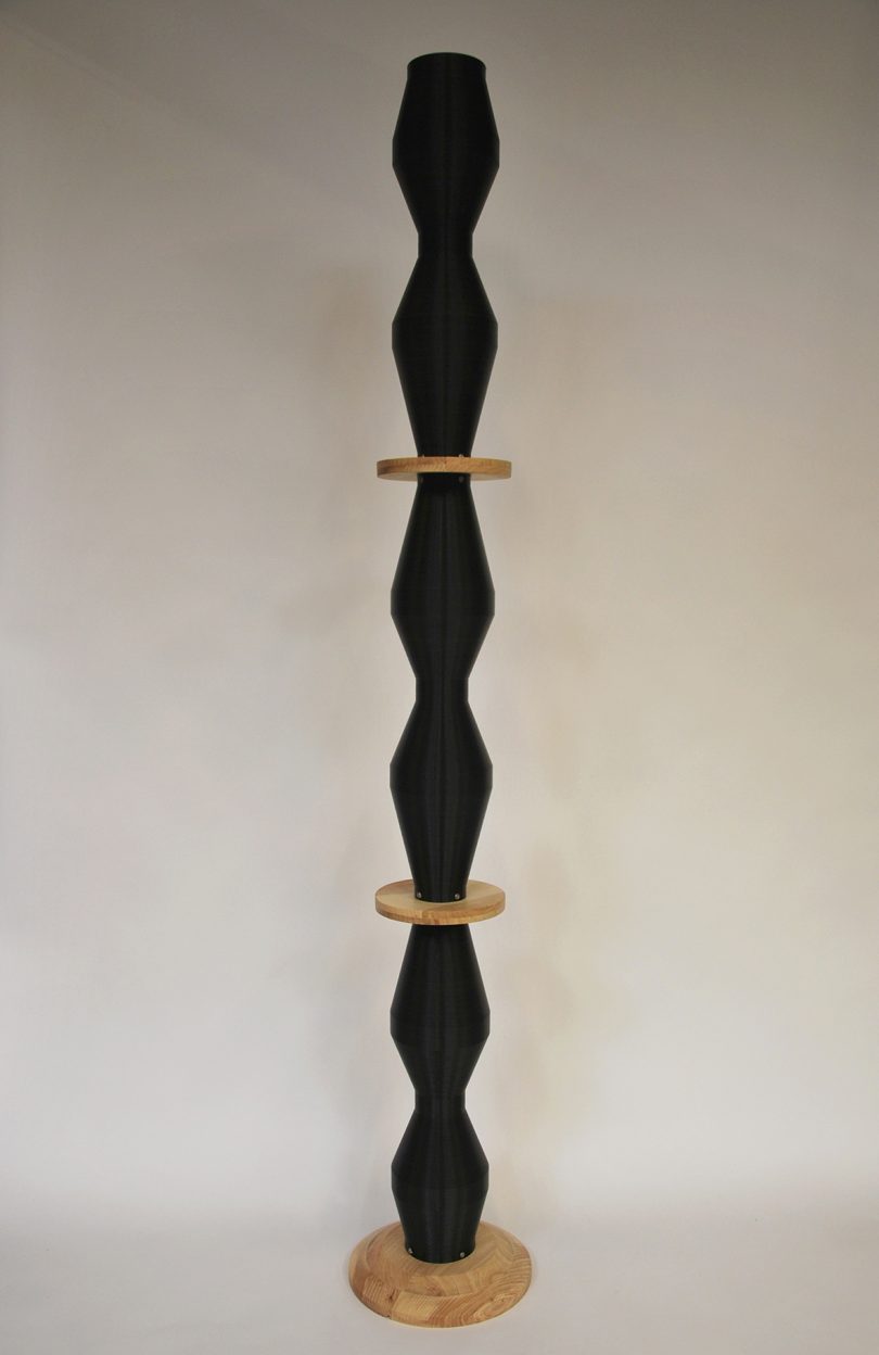 curvaceous black column punctuated by wooden disks