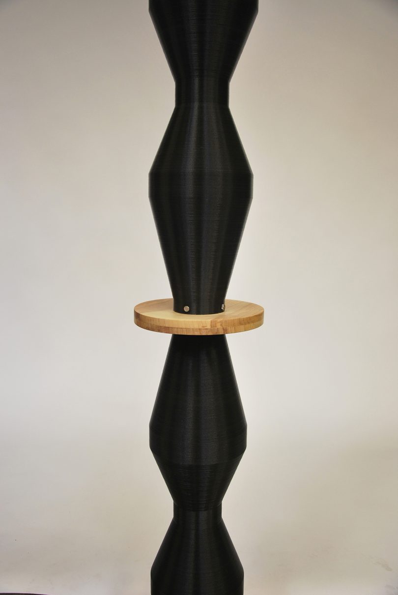 detail of curvaceous black column punctuated by wooden disks