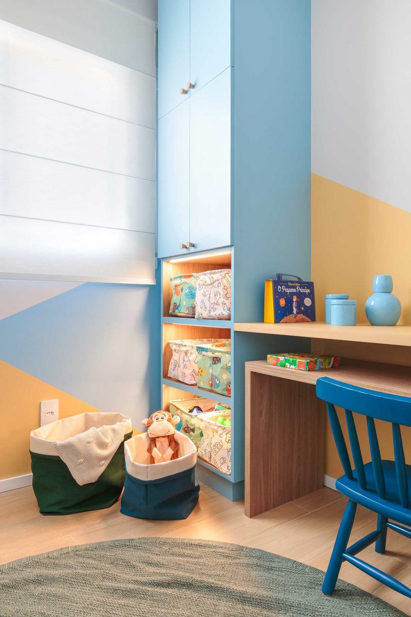 angled view of modern kid's room with graphic blue and peach walls and built-in storage