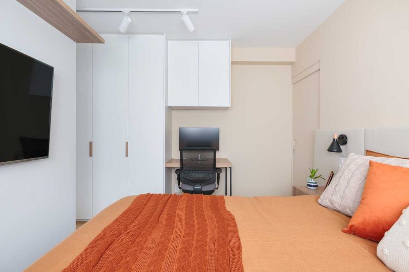 side view of bedroom in modern apartment with peach bedding
