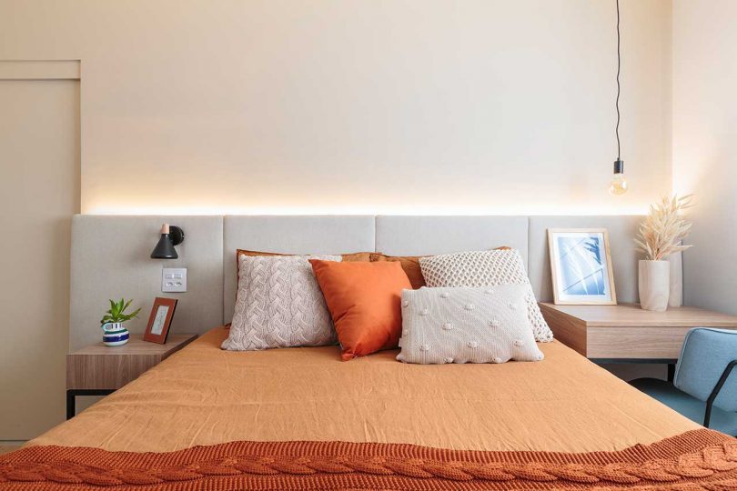 view of bedroom in modern apartment with peach bedding