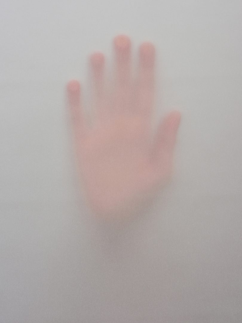 hand pressed up against a foggy surface