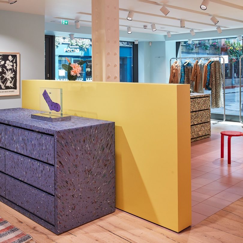 angled view of store with yellow half wall and purple terrazzo like dresser