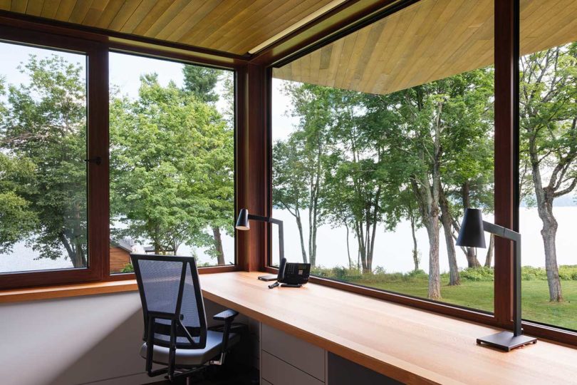 corner window view of modern interior home office looking out to trees
