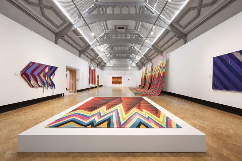 exhibition gallery featuring graphic multicolor textile art