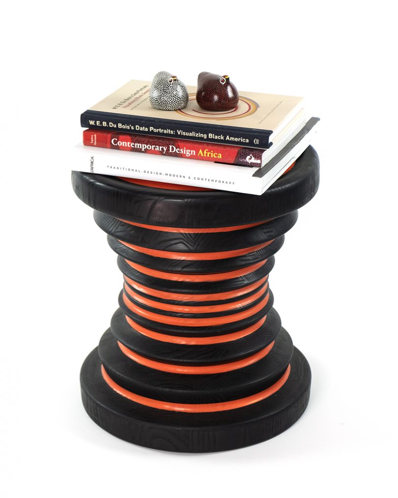 black and orange hourglass-shaped stool with stacked books