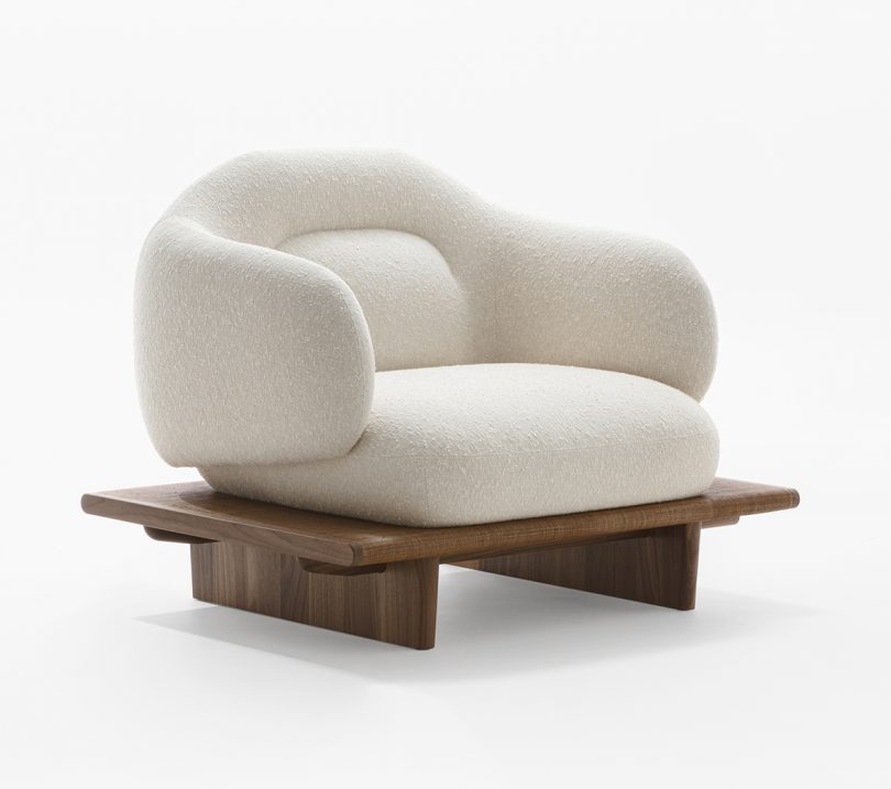white upholstered armchair on a wooden platform base